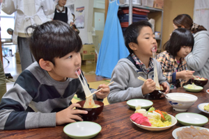 餅を頬張る子どもたちの画像