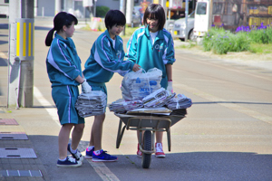 一輪車に古紙を載せる生徒の画像