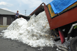 雪をトラックから降ろしている画像