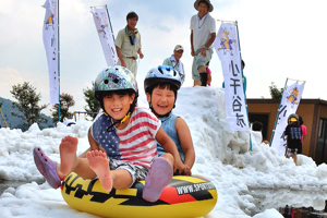 雪の滑り台で遊ぶ子どもたちの画像