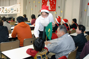 プレゼントを渡す生徒と受け取る子どもの画像