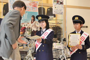 笑顔でチラシと花の種を渡す一日消防署長の画像