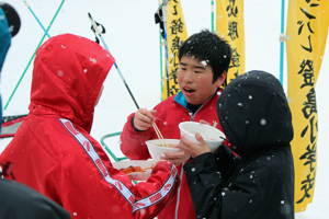 無料のとん汁を食べる選手たちの画像