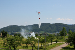 上空から放水する防災ヘリコプターの画像