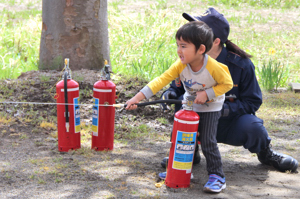 消火器の使い方を学ぶ子どもの画像