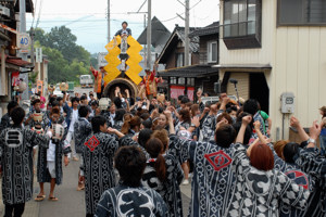 元気良く花火の筒を引く若者の画像