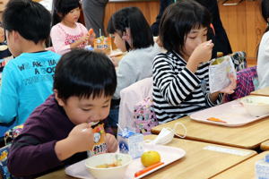 給食を食べる児童の画像