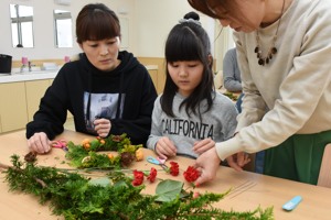 リースを飾り付けていく親子の画像