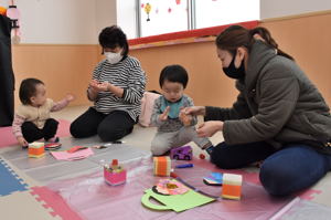 ひなまつり飾りを作る親子の画像