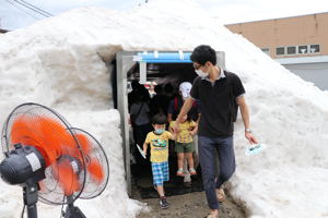 雪山のトンネルをくぐる親子の画像