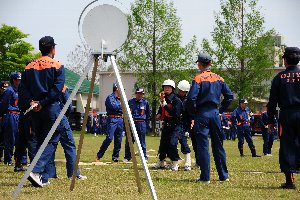 真剣なまなざしでホースを構える消防団員の画像