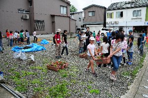 花を植え終わったプランターを運んでいる画像