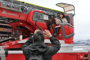 はしご車の操縦席で笑顔を見せる女の子の画像