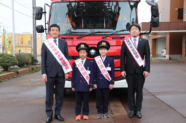 消防車の前に並ぶ小学生の画像