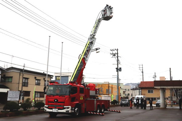 クレーンを伸ばしたはしご車の画像