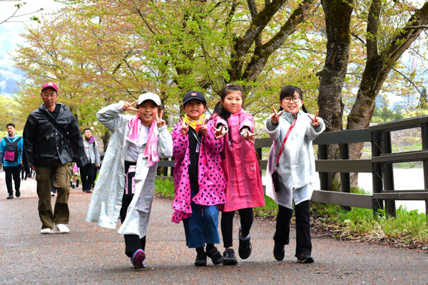 笑顔でピースサインをする女の子の画像