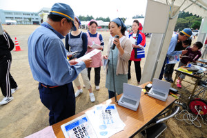 災害時衛星電話の説明を受ける参加者の画像