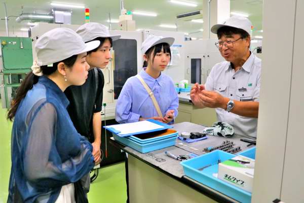 工場を訪問し製品の説明を聞く学生の画像