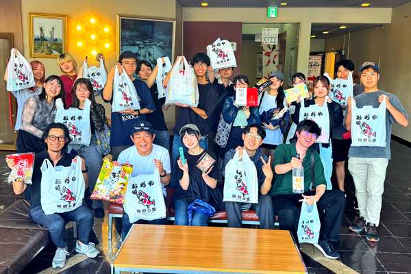 最終日におみやげを買って集合写真を撮る参加者の画像
