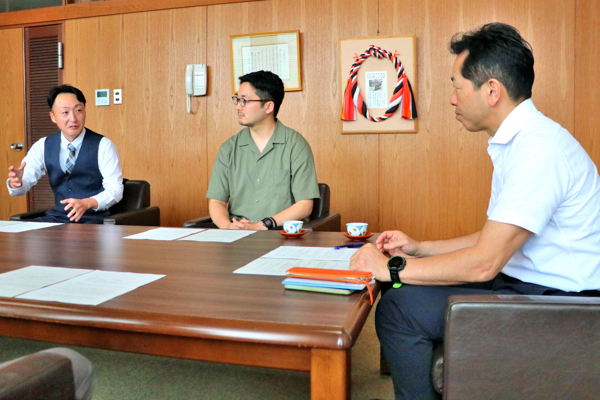 豊田さんの活動報告を聞く谷口さんと市長の画像