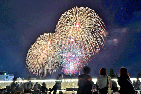 スターマイン花火と花火を見る観客の画像
