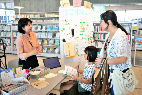 コトノハ体験ができるマルシェに来た親子に職員が説明している画像