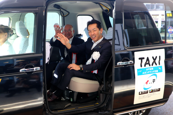 イコテの車両から宮崎市長とイコテの愛称を提案した猪俣さんが手を振っている画像
