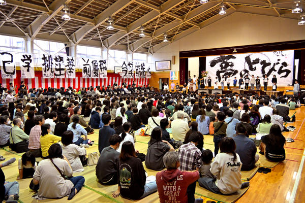 児童の合奏を聞くおおぜいの保護者の画像