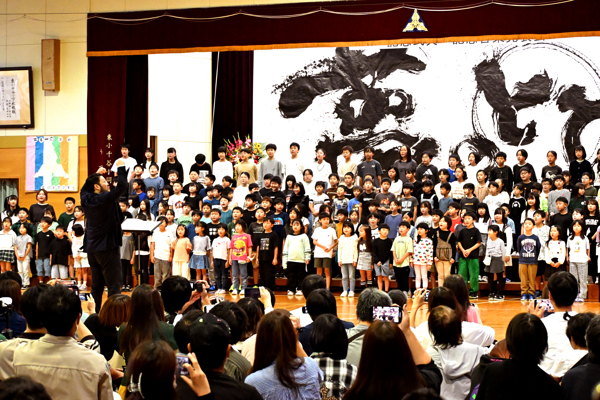 統合100周年記念の歌を斉唱する全校児童の画像