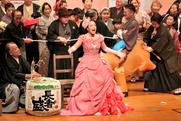 派手なドレスを着て歌うムゼッタの画像