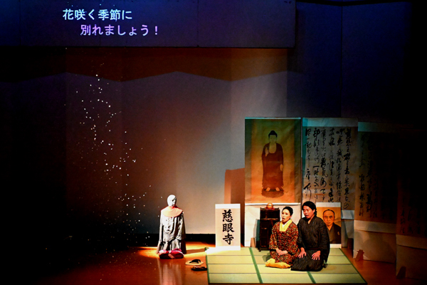 雪が降る演出がされている舞台で歌うロドルフォとミミの画像