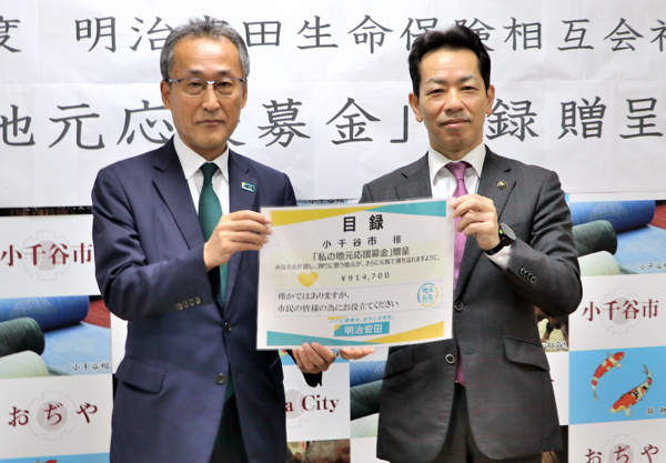 寄附金の目録を持つ宮崎市長と明治安田の赤木支社長の画像