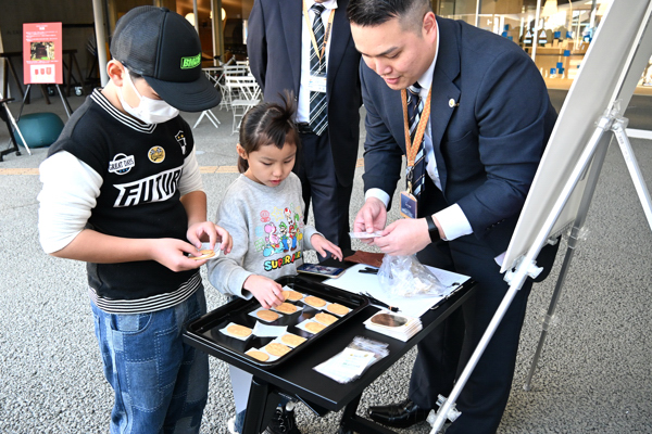 完成した小判を受け取る男の子と女の子の画像