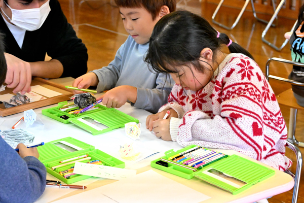 トントン角突きの色塗りをする園児の画像