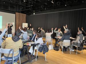 参加者が意見に同意し手を挙げている様子の画像