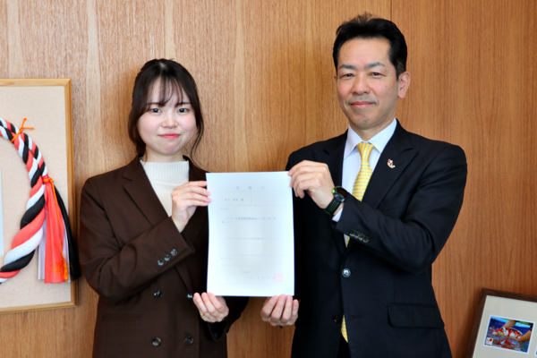 辞令交付の書類を持つ星出さんと宮崎市長の画像