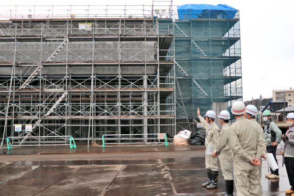 屋外で説明を受ける見学会参加者たちの画像