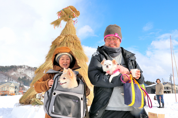 会場で犬を抱える家族の画像