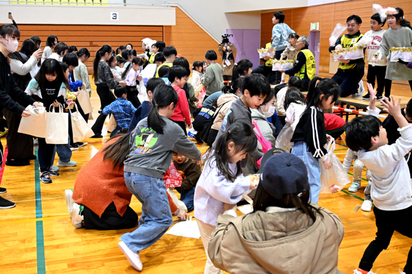 お菓子や餅を拾う子どもたちの画像
