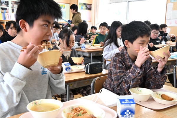 給食を食べる児童の画像