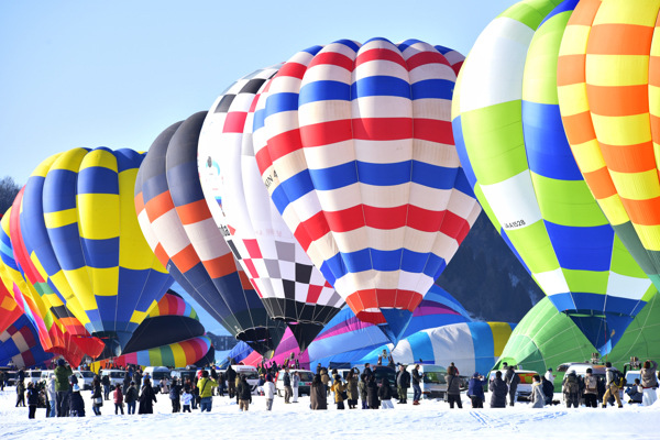 競技フライトで並ぶ多くの気球の画像