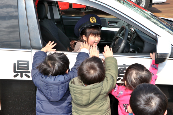 パトカーの運転席に乗る女の子の画像
