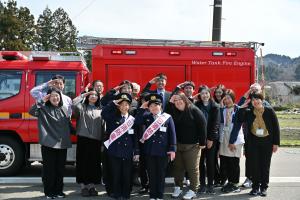 和泉小学校の先生たちと記念撮影をする小学生
