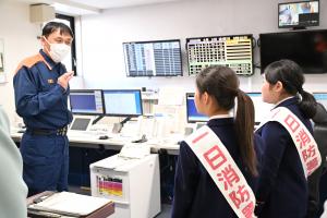 通信指令室で説明を真剣に聞く小学生