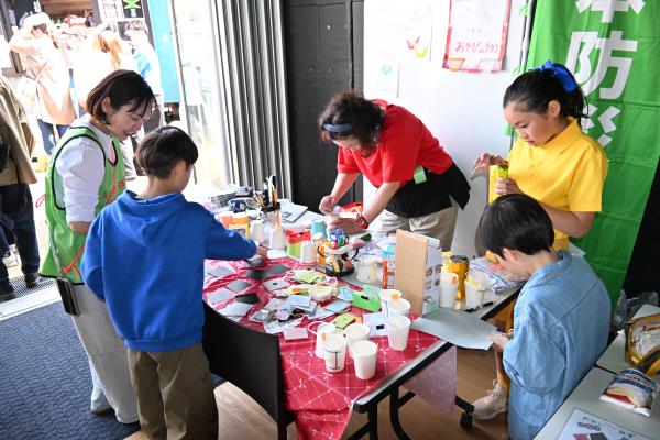 防災ブースで遊ぶこどもと防災士たちの画像