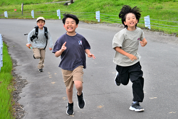 坂道を走る三人の男の子の画像