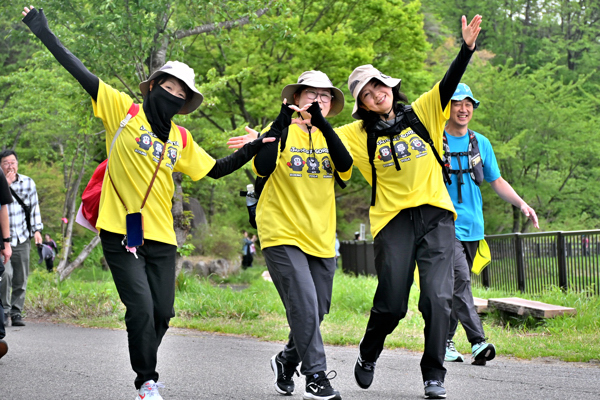 歩きながら手を広げるポーズをしている三人の女性の画像