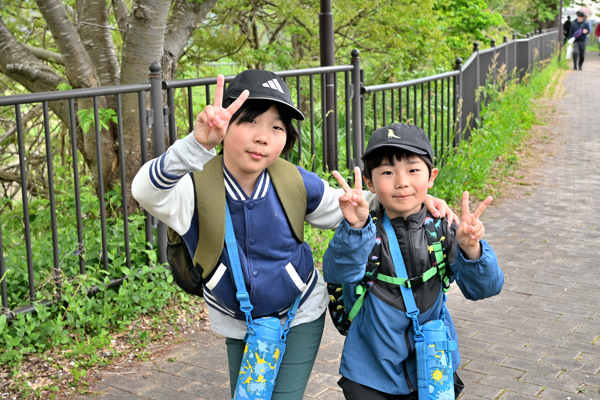 遊歩道でピースサインをする男の子2人の画像