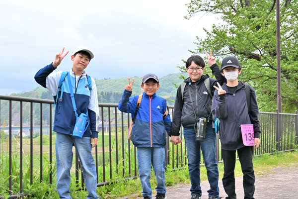 遊歩道でピースサインをする小学生男子4年の画像