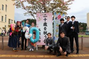 看板前で記念写真を撮る二十歳のみなさん
